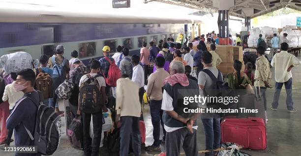 Travellers flouting social distancing norms while waiting at the platform at New Delhi railway station , on March 23, 2021 in New Delhi, India.
