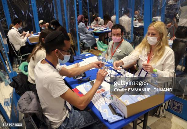 Electoral workers count ballots in Israel's general elections in Jerusalem on March 25, 2021. - As the count continues in Israel's March 23 general...