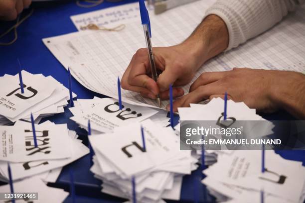 Electoral workers count ballots in Israel's general elections in Jerusalem on March 25, 2021. - As the count continues in Israel's March 23 general...