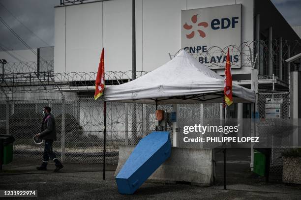 Man walks past a coffin displayed by union members during a protest against the planned 'Hercules' restructuring deal proposed for state-controlled...