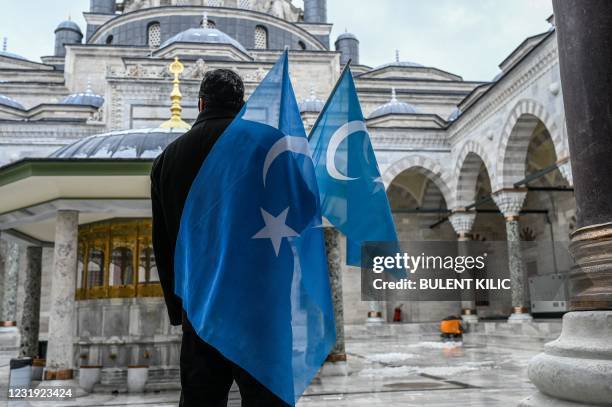 Protester from the Uyghur community living in Turkey stands with flags in the Beyazit mosque during a protest against the visit of China's Foreign...