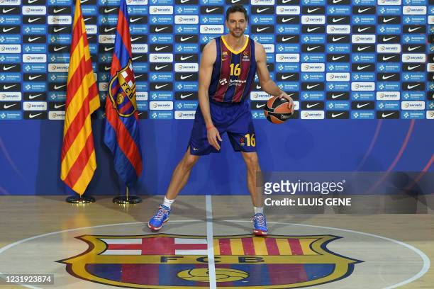 Spanish pivot Pau Gasol poses during his official presentation as new player of FC Barcelona Basket at the Palau Blaugrana in Barcelona on March 25,...
