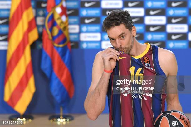 Spanish pivot Pau Gasol kisses Barcelona's crest as he poses during his official presentation as new player of FC Barcelona Basket at the Palau...