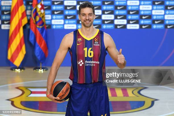 Spanish pivot Pau Gasol gives a thumbs-up as he poses during his official presentation as new player of FC Barcelona Basket at the Palau Blaugrana in...