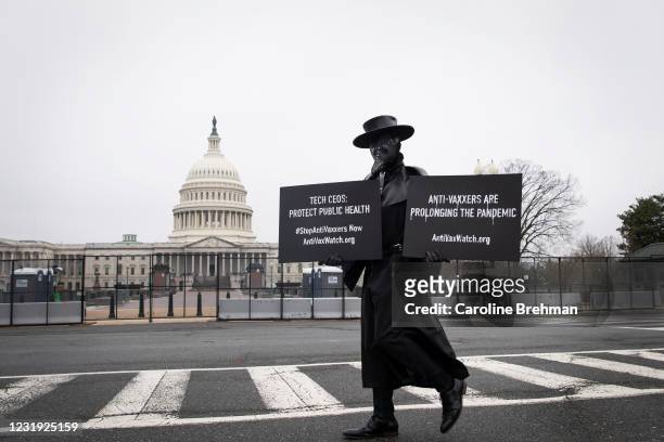 March 25: A man dressed up as a plague doctor stands outside of the fencing on the East Front of the Capitol ahead of the House Energy and Commerce...