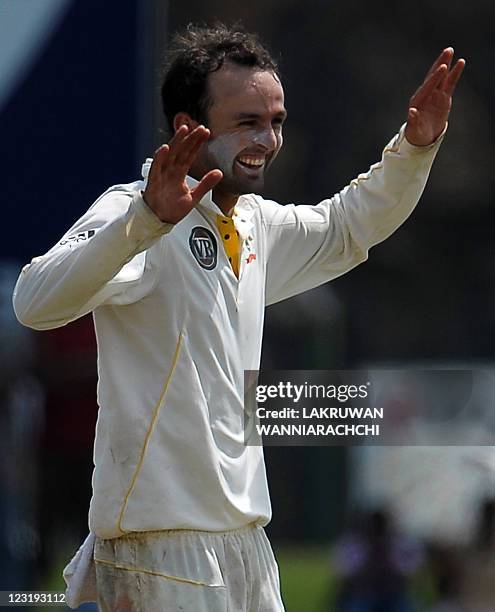 Australia cricketer Nathan Lyon celebrates after he dismissed unseen Sri Lankan batsman Rangara Herath during the second day of the opening Test...