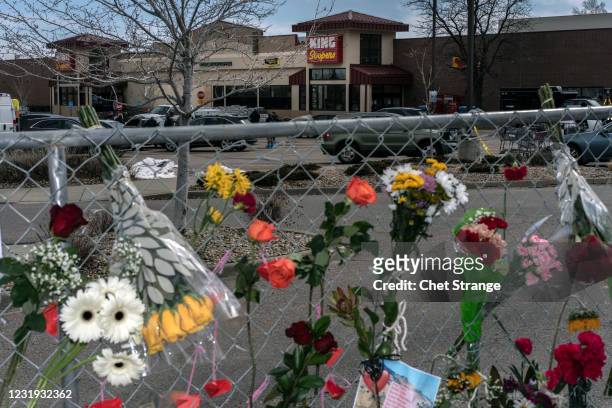 Flowers line a fence at a makeshift memorial for the victims of the shooting at a King Soopers grocery store on March 25, 2021 in Boulder, Colorado....