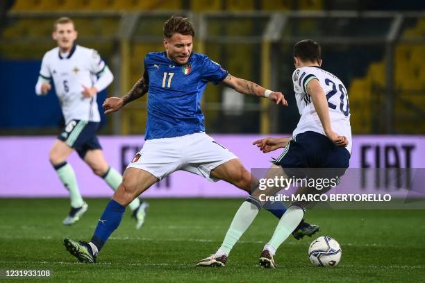 Italy's forward Ciro Immobile and Northern Ireland's defender Craig Cathcart go for the ball during the FIFA World Cup Qatar 2022 Group C...