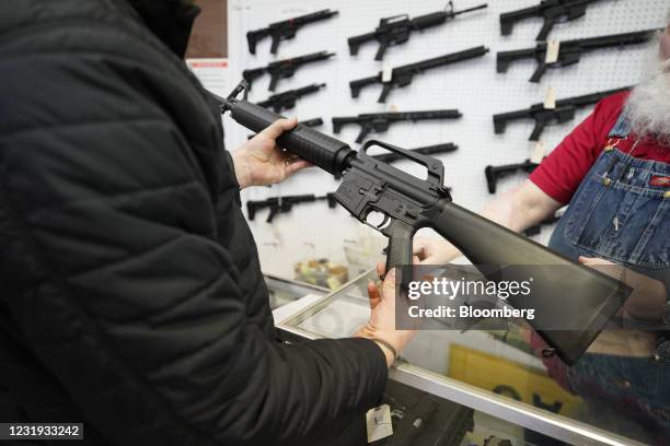 Salesperson shows an AR-15 rifle to a customer at a store in Orem, Utah, U.S., on Thursday, March 25, 2021. Two mass shootings in one week are giving...