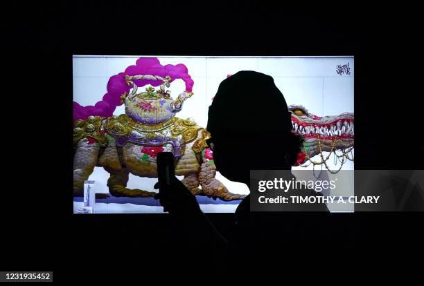 Person takes a photo during a press preview on March 25, 2021 of the grand opening of Superchief Gallery NFT, a physical gallery dedicated...
