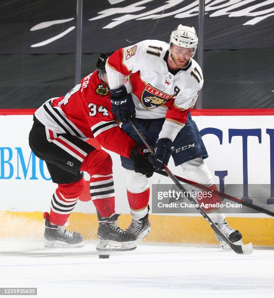 Jonathan Huberdeau of the Florida Panthers and Carl Soderberg of the Chicago Blackhawks battle for the puck in the first period at the United Center...