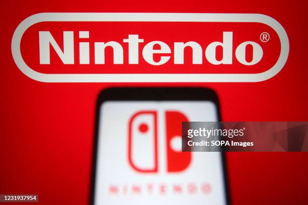 In this photo illustration the Nintendo logo of a Japanese consumer electronics and video game company is seen on a smartphone and a pc screen.