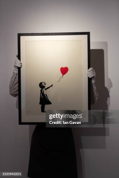 Girl with Balloon by Banksy is displayed during preparations ahead of online sales at Christies Auction House on March 26, 2021 in London, England....