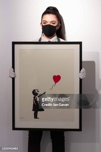 Girl with Balloon by Banksy is displayed during preparations ahead of online sales at Christies Auction House on March 26, 2021 in London, England....