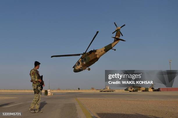 In this photograph taken on March 25, 2021 an Afghan Commandos soldier stands guard as an Afghan Air Force Black Hawk helicopter takes off at the...