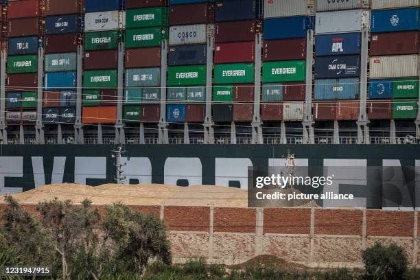 March 2021, Egypt, Suez: An Egyptian Army soldier stands on a hill in front of "Ever Given", a container ship operated by the Evergreen Marine...