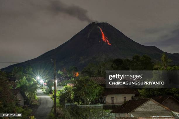 Lava flows down from the crater of Mount Merapi, Indonesia's most active volcano, as seen from Tunggul Arum in the city of Turi near Yogyakarta early...