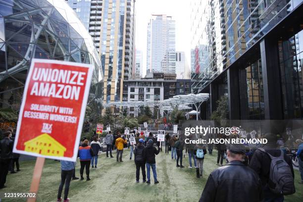 People hold pro-union signs during a rally at the Amazon Spheres and headquarters in solidarity with Amazon workers hoping to unionize in Bessemer,...