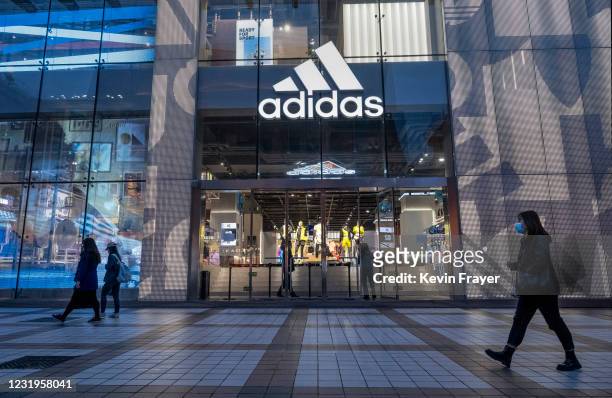 People walk by an Adidas store at a shopping area on March 26, 2021 in Beijing, China. Chinese state media and social networking platforms called for...