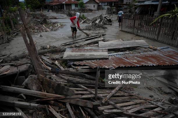Residents and volunteers cleaned up the remaining mud that hit houses in Beka Village, Marawola District, Sigi Regency, Central Sulawesi Province,...