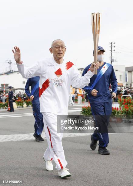 Kenji Kimihara, silver medalist of the 1968 Mexico Olympic marathon, takes part in the Tokyo Olympic torch relay in the Fukushima Prefecture city of...