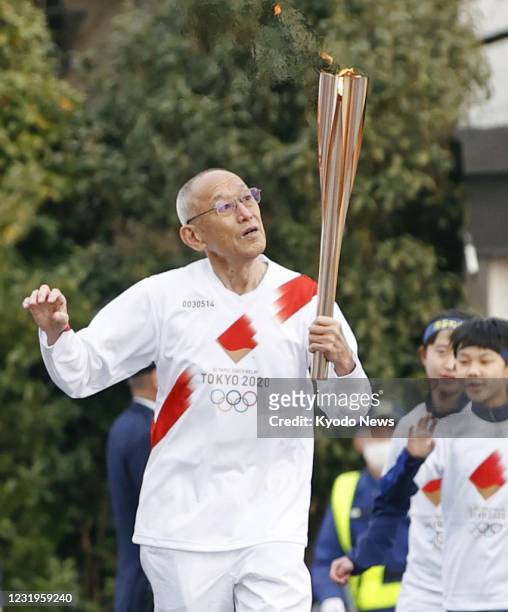 Kenji Kimihara, silver medalist of the 1968 Mexico Olympic marathon, takes part in the Tokyo Olympic torch relay in the Fukushima Prefecture city of...