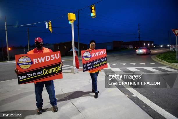 Union organizers Syrena and Steve stand outside an Amazon fulfillment center on March 27, 2021 in Bessemer, Alabama. - Amazon Alabama workers are...