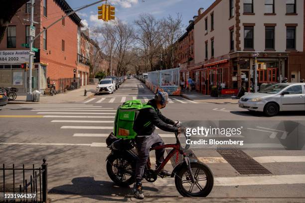 An Uber Eats delivery courier rides an electric bicycle through the Park Slope neighborhood of the Brooklyn borough of New York, U.S., on Friday,...