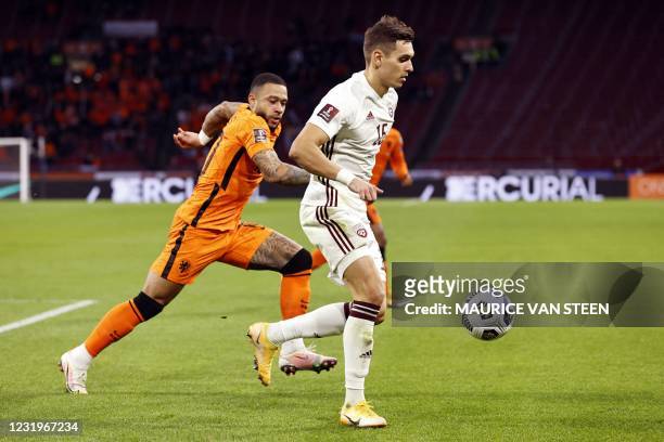 Dutch forward Memphis Depay fights for a against Latvia's midfielder Vladislavs Fyodorovs during their World Cup qualifying Group G match between the...