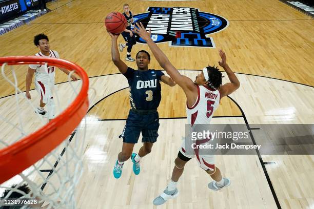 Max Abmas of the Oral Roberts Golden Eagles goes up for a shot against Moses Moody of the Arkansas Razorbacks in the Sweet Sixteen round of the 2021...
