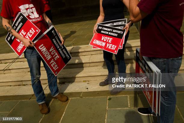 People hold "Vote Union Yes!" signs during a protest in solidarity with Black Lives Matter, Stop Asian Hate and the unionization of Amazon.com, Inc....