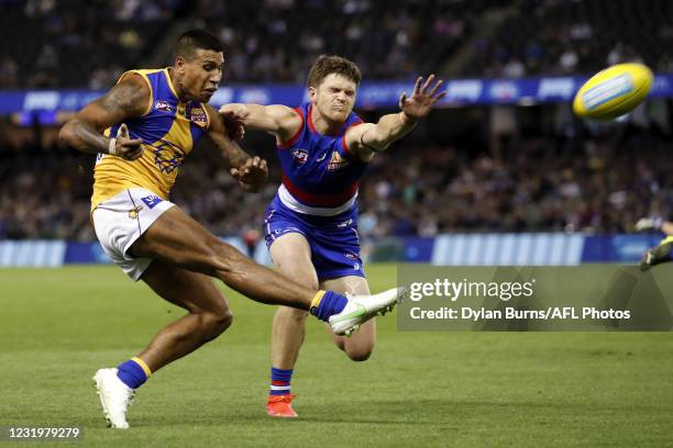 Tim Kelly of the Eagles kicks the ball ahead of Taylor Duryea of the Bulldogs during the 2021 AFL Round 02 match between the Western Bulldogs and the...