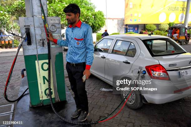 Worker refill a vehicle by CNG which is an eco-friendly alternative to gasoline at a CNG Refilling station. CNG fuel is safer than gasoline and...