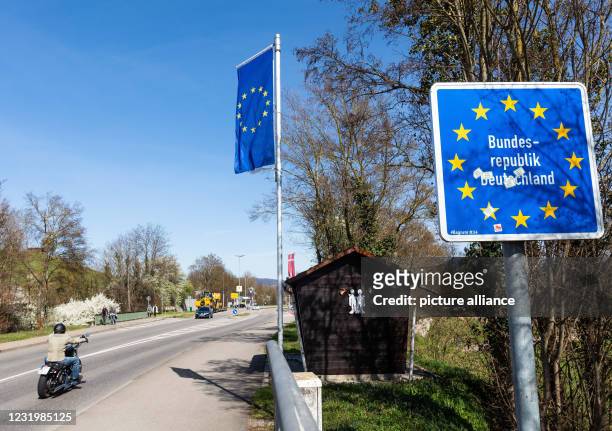 March 2021, Baden-Wuerttemberg, Breisach am Rhein: A sign on the German-French border indicates the beginning of German territory as a motorcyclist...