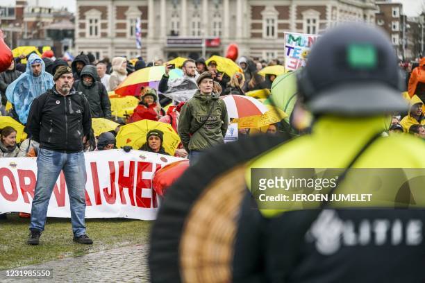 Dutch riot police watch campaigners in military clothing as they gather with protesters on the Museumplein for the so-called Coffee Drink campaign to...