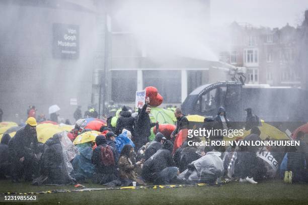 Dutch riot police intervenes with a water cannon as protesters gather on the Museumplein for the so-called Coffee Drink campaign to denounce the...