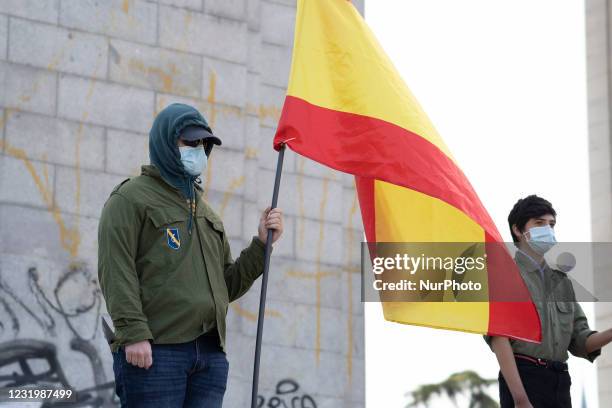 Spanish flag waves in the air during a gathering of right-wing supporters at Arco de la Victoria commemorating the 82nd anniversary of the date when...