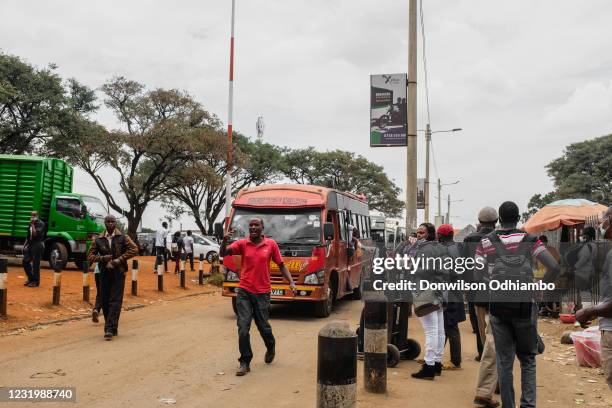 Passengers walk through Nairobi Cross County bus station after a cessation of movements in and out of the Nairobi Metropolitan Area on March 28 2021...