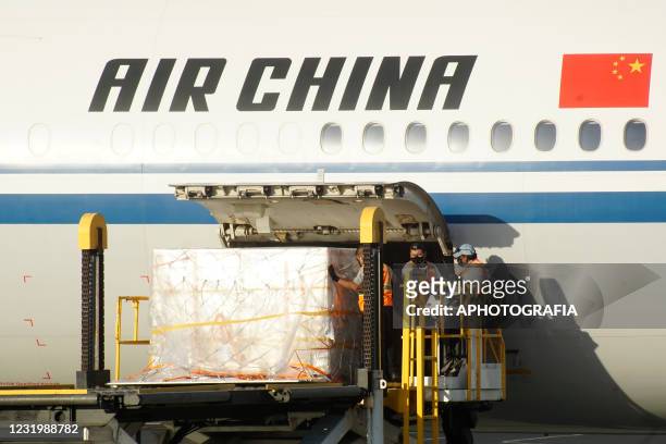 Workers unload vaccine doses from an Air China flight during the arrival of a new batch of Sinovac vaccines against Covid-19 at El Salvador...