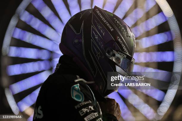 Mercedes' British driver Lewis Hamilton removes his helmet in parc ferme after the Bahrain Formula One Grand Prix at the Bahrain International...
