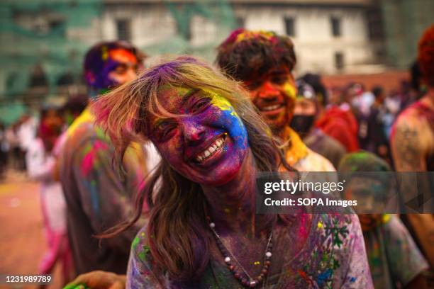 Face of a reveller smeared with colours as she celebrates Holi festival. Holi is a popular Hindu festival filled with so much fun and is celebrated...