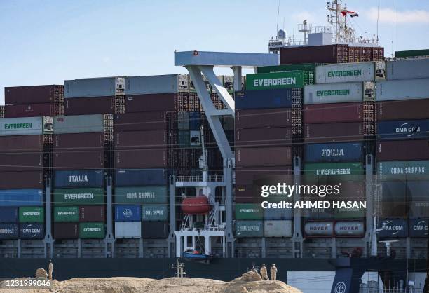 Egyptian army soldiers stand on guard near the grounded Panama-flagged container ship MV 'Ever Given' , the 400-metre- long and 59-metre wide vessel...