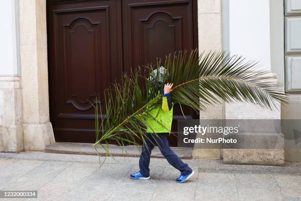 Boy carries a palm leaf on Palm Sunday in Krakow, Poland on March 28, 2021. During Palm Sunday, which is also called The Sunday of the Lord's...