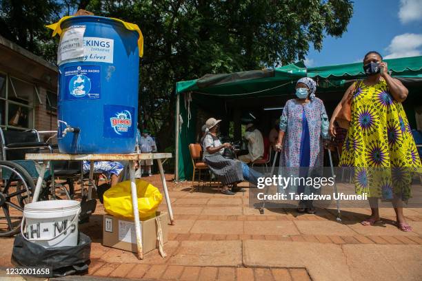 An elderly woman is seen leaving the tent after vaccination at a local hospital on March 29, 2021 in Harare, Zimbabwe. The country is now focusing...