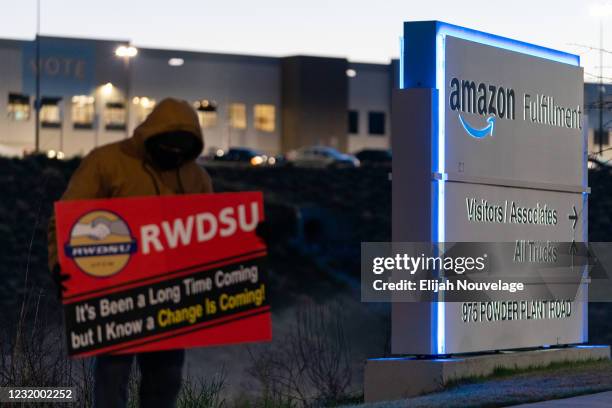 An RWDSU union rep holds a sign outside the Amazon fulfillment warehouse at the center of a unionization drive on March 29, 2021 in Bessemer,...