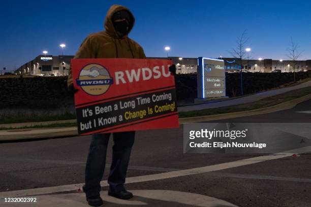 An RWDSU union rep holds a sign outside the Amazon fulfillment warehouse at the center of a unionization drive on March 29, 2021 in Bessemer,...