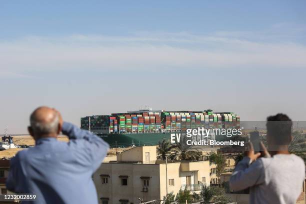 Spectators watch as the Ever Given container ship moves along the Suez Canal towards Ismailia after being freed from the canal bank in Suez, Egypt,...