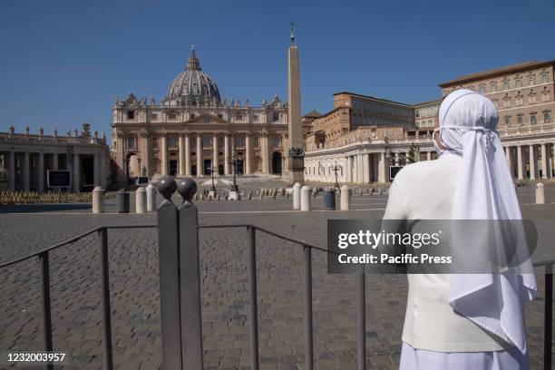 Nun with an olive branch prays on Palm Sunday in St. Peter's Square in Rome.