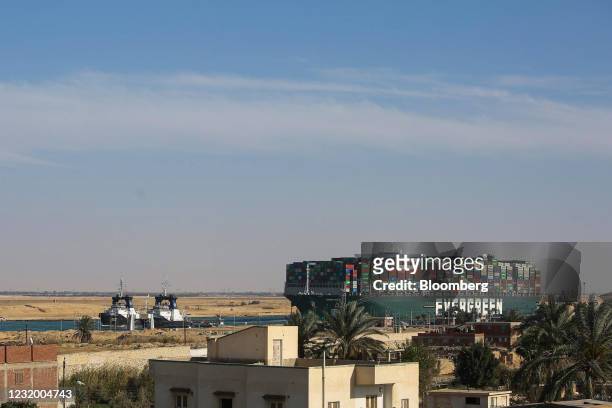 Tug boats pull the Ever Given container ship along the Suez Canal after being freed from the canal bank in Suez, Egypt, on Monday, March 29, 2021....