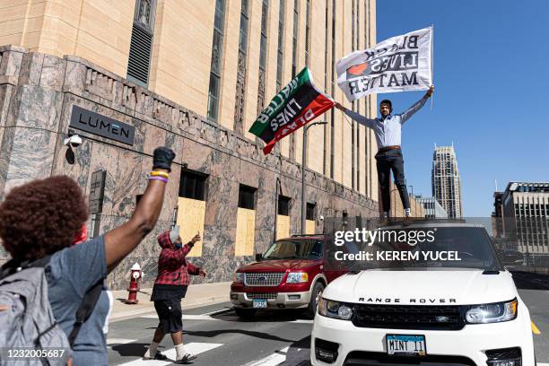 Christ Forest, waves "Black Lives Matter" flags on top of his car outside the Hennepin County Government Center during the opening statement of...